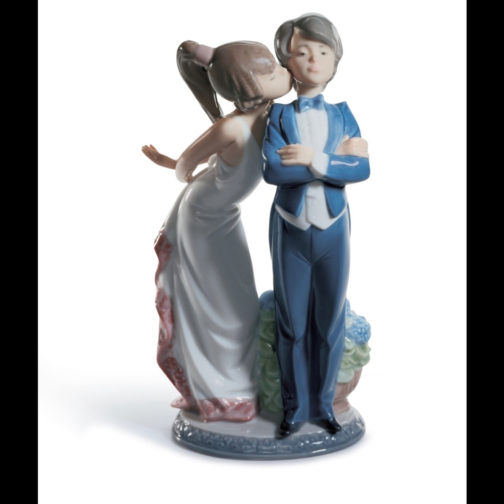 Lladro figurine of a young couple she is giving him a kiss on the cheek.